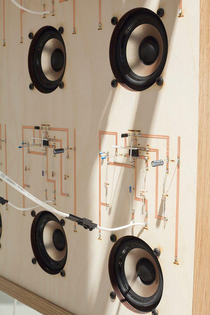 This is a close up picture of the speakers on a machine. There is electrical wiring and one string coming out of each speaker. The machine is light beige.