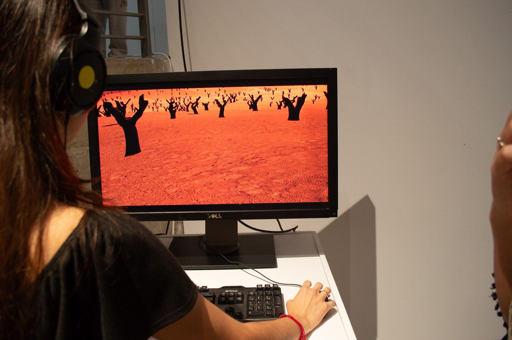 A participant uses the keyboard, mouse, and headphones, and moves through the barren desert landscape.